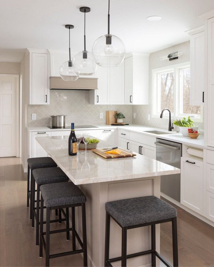 Luxury white kitchen with marble waterfall island and stainless range
