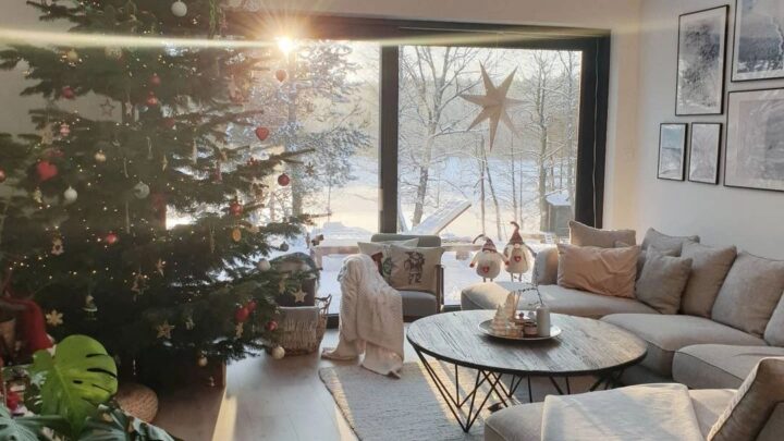 Cozy Christmas living room with large windows and winter view