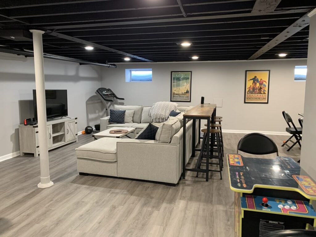 Multi-use basement with media setup, game zone, and seating areas