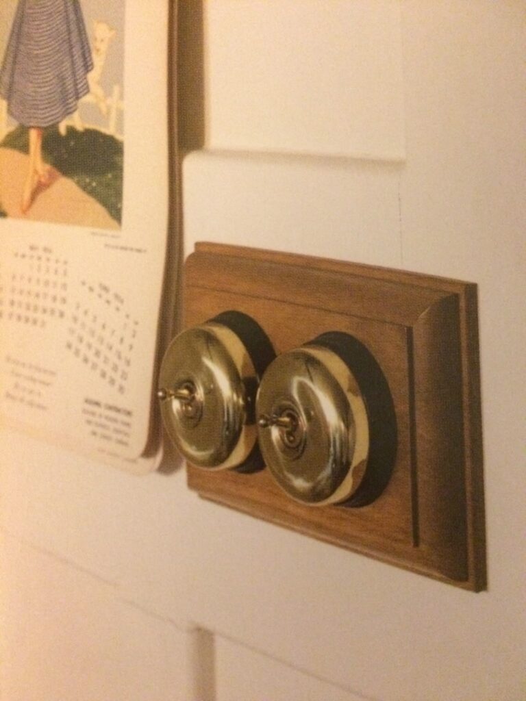 Vintage brass light switches on wooden wall plate